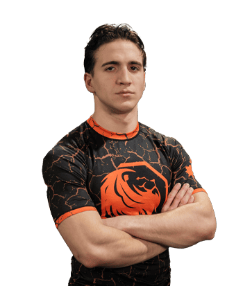 Luca Martinez wearing a black and orange esports jersey with a lion logo, standing confidently with arms crossed.